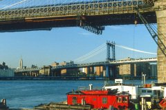 Blick von Brooklyn unter der Brooklyn Bridge hindurch im Abendlicht (1987)